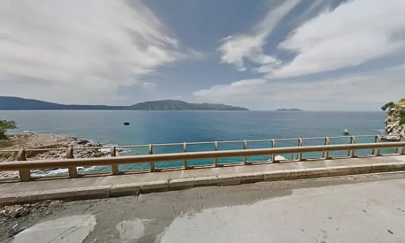 ¿En qué país se ve esta gran bahía junto a una carretera costera?