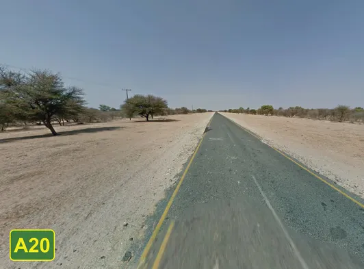 ¿En qué país se ve esta carretera recién asfaltada con tramos inusualmente angostos y tierra roja alrededor?