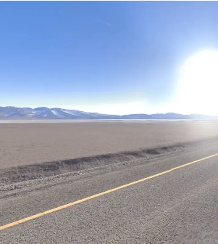 ¿En qué país se ve este paisaje abierto con salares y arena rojiza?
