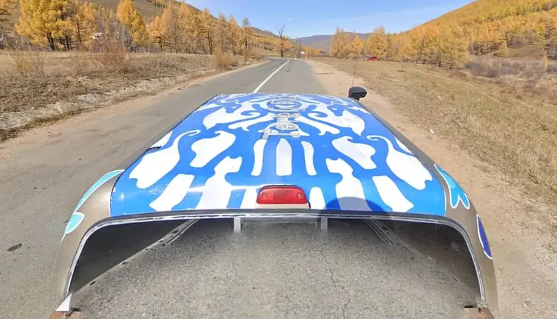 In which country do you see this Street View pickup truck with a tent or blue-and-white paint, on a vast, treeless grass steppe?