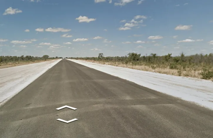 ¿En qué país verías esta carretera muy ancha, recién pavimentada, sin líneas todavía y con los bordes removidos?