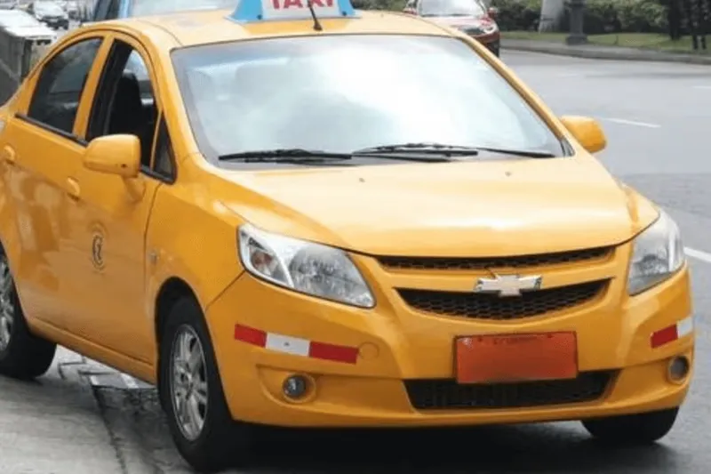¿En qué país se ven placas anaranjadas con calcomanías rojas y blancas como esta en taxis y vehículos comerciales?