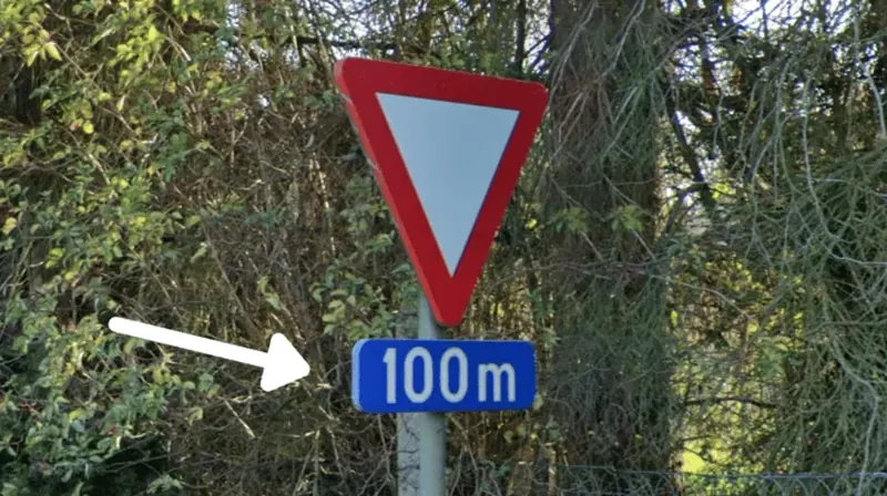 ¿En qué país se ve esta pequeña placa azul complementaria bajo una señal de tráfico?